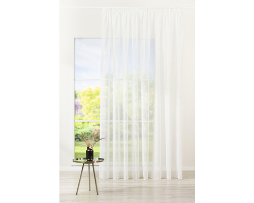 Fereastră cu material de perdea alb, transparent, care creează o atmosferă luminoasă și aerisită