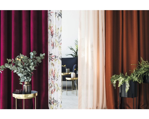 Ambianță decorativă cu diverse perdele și plante pe măsuțe laterale