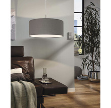 Lampa suspendată din material textil deasupra unei canapele în sufragerie.