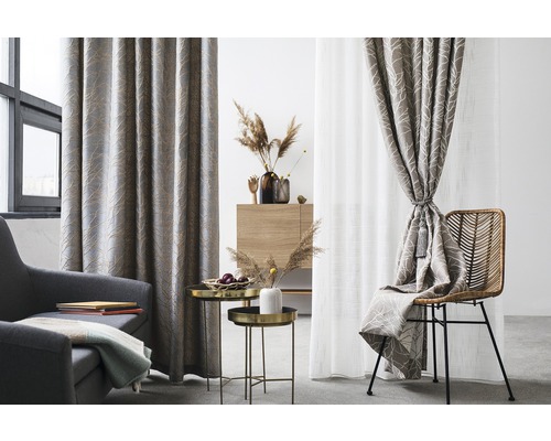 Living cu fotoliu, măsuțe laterale și ferestre decorate cu perdele