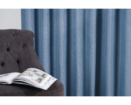 Cortină decorativă lângă un fotoliu cu o carte