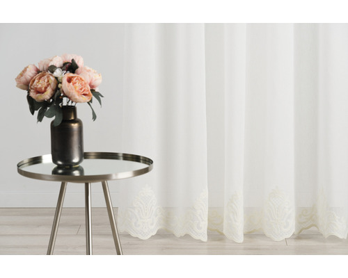 Perdea decorativă transparentă cu broderie și buchet de flori pe o masă