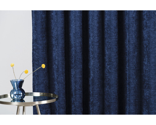 Cortină decorativă din material textil lângă o măsuță laterală cu flori într-o vază.