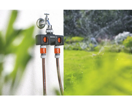 Distribuitor de apă Gardena pe un robinet cu două furtunuri de grădină conectate.