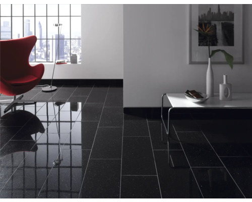 Cameră de zi cu gresie neagră lucioasă, fotoliu, masă și fereastră