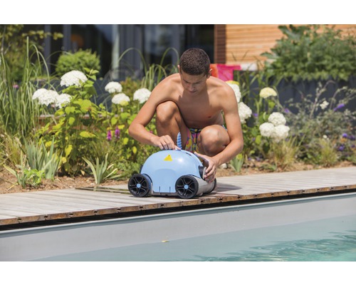 Un bărbat pregătește un robot de piscină pentru curățare.