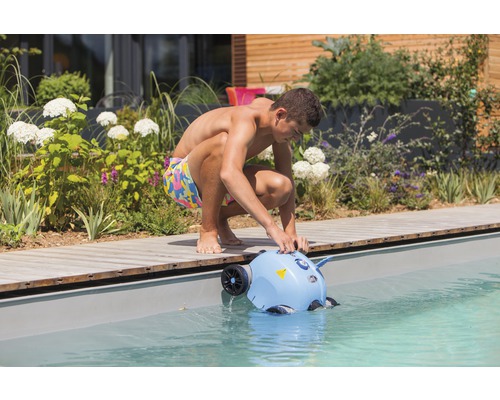 Un bărbat introduce un robot de curățare a piscinei într-o piscină.