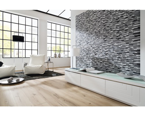 Cameră de zi luminoasă cu parchet, perete mozaicat și ferestre mari