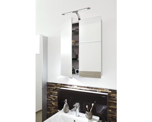 Dulap cu oglindă cu iluminare deasupra unei chiuvete în baie.