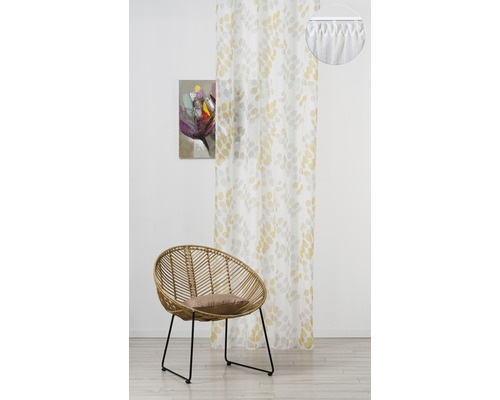 Cameră decorativă cu o perdea cu model, un scaun de ratan și un tablou abstract