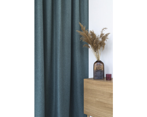 Cortină decorativă lângă o masă din lemn cu o vază cu iarbă ornamentală