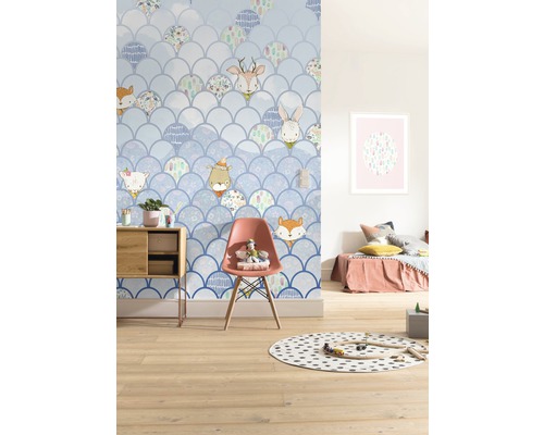 Cameră de copii cu tapet cu design de solzi și motive de animale, decorată cu mobilier și jucării.