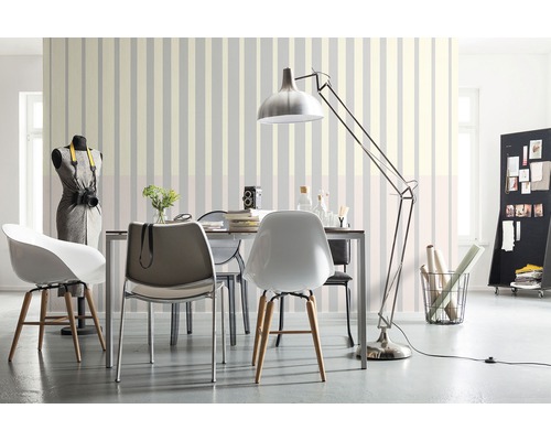 Cameră de zi cu masă de dining, scaune, lampadar și tapet cu dungi pentru un ambient luminos și organizat.