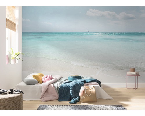 Cameră de zi cu fototapet care prezintă un peisaj marin cu plajă și o barcă cu pânze.