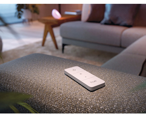 Telecomandă Philips Hue pe un scaun într-o sufragerie