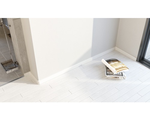 Cameră luminoasă cu reviste pe podea laminată și ustensile pentru șemineu.