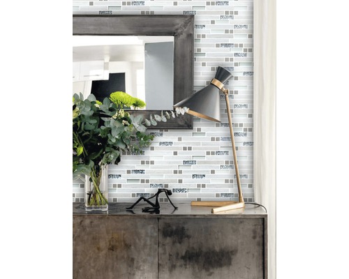 Decor de perete cu plăci de mozaic în stil modern, cu oglindă și lampă pe un dulap.