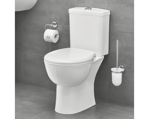 Toaletă albă de podea cu rezervor, suport de hârtie igienică și perie de toaletă în baie