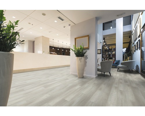 Cameră luminoasă cu podea aspect lemn, recepție și zonă de relaxare