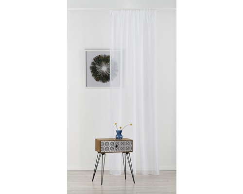 Cameră decorativă cu draperie albă transparentă, noptieră și tablou de perete.