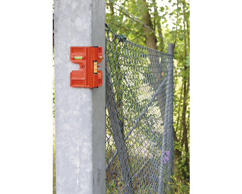 Nivelă de gard portocalie pe un stâlp de gard pentru aliniere în timpul construcției gardului