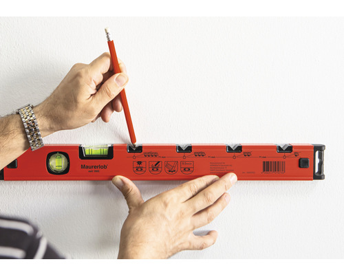 O persoană marchează un loc pe un perete cu un creion și o nivelă.