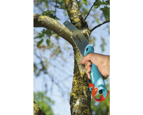 Persoană taie o ramură cu un fierăstrău de mână Gardena