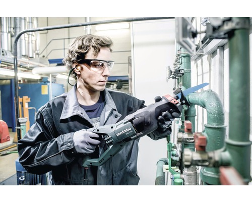 Un bărbat taie o țeavă cu un fierăstrău pendular Metabo