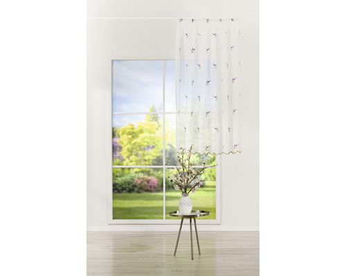 Atmosferă decorativă de locuit cu perdea de fereastră, vază și aranjament floral pe o măsuță în fața ferestrei