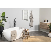 Baie luminoasă cu cadă, lavoar, radiator pentru prosoape și decorațiuni pentru o atmosferă prietenoasă.
