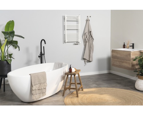 Baie luminoasă cu cadă, lavoar, radiator pentru prosoape și decorațiuni pentru o atmosferă prietenoasă.