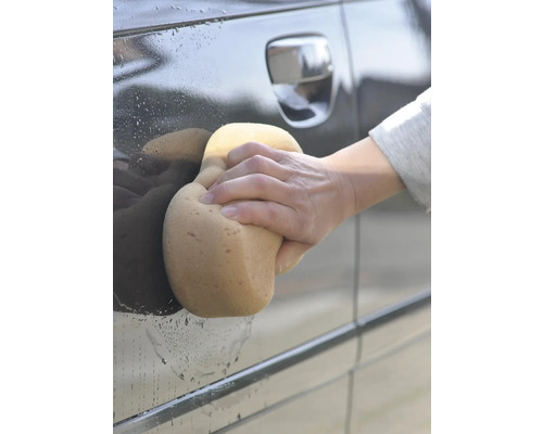 O mașină este spălată cu un burete.