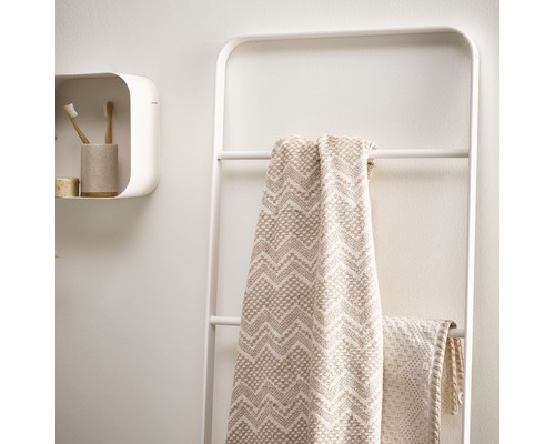 Scenă de baie cu scară pentru prosoape, prosoape și raft de perete