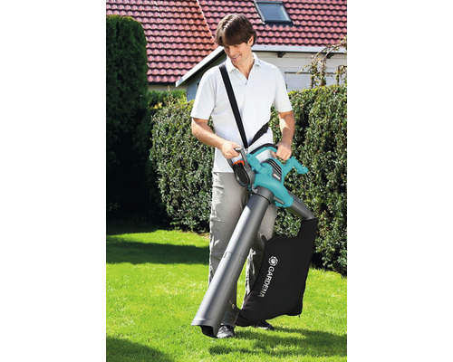 Un bărbat folosește un aspirator de frunze în grădină cu sac de colectare.