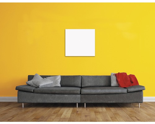 Camera de zi cu canapea gri, perne și ramă pătrată goală pe perete