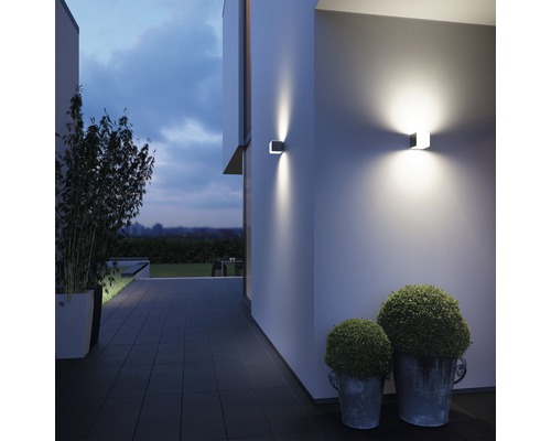 Fațadă modernă de casă cu aplice de perete pătrate și plante decorative