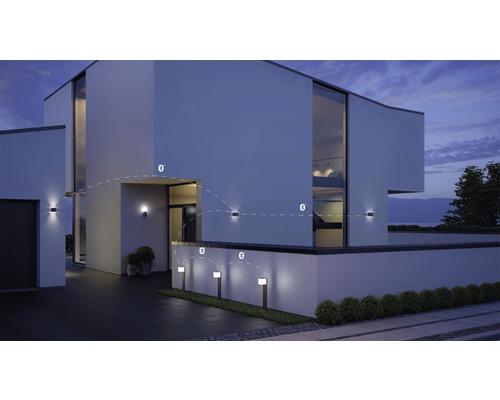 Fațadă modernă de casă cu lumini exterioare și lumini de cale conectate prin Bluetooth.