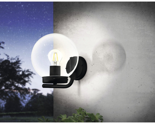 Lampa de perete cu abajur rotund de sticlă și bec pe un perete
