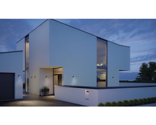 Casă modernă cu iluminat exterior și ferestre mari la amurg