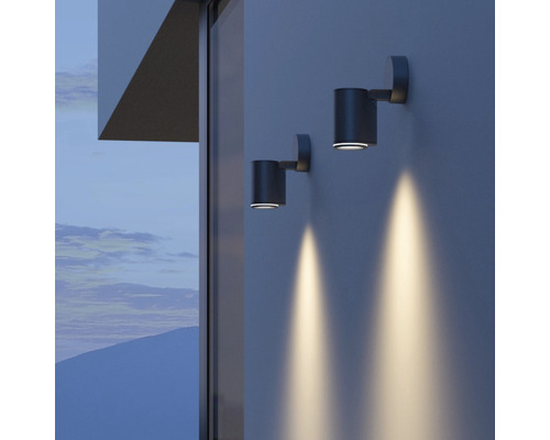 Două lămpi de perete gri iluminează un perete.