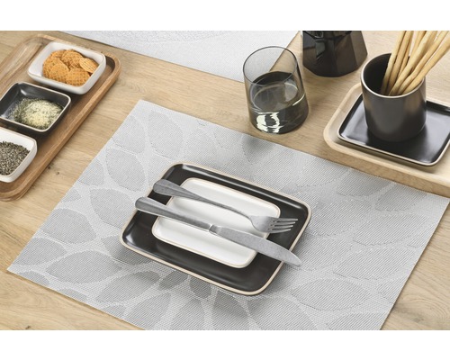 Decor de masă cu suport de farfurie, veselă și tacâmuri pe masă de lemn