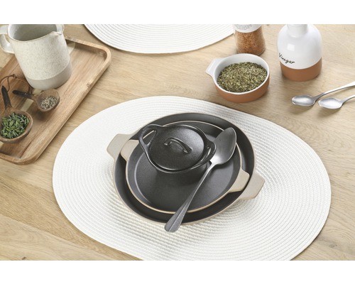 Masă aranjată cu suporturi de farfurie, farfurii, boluri și linguri.