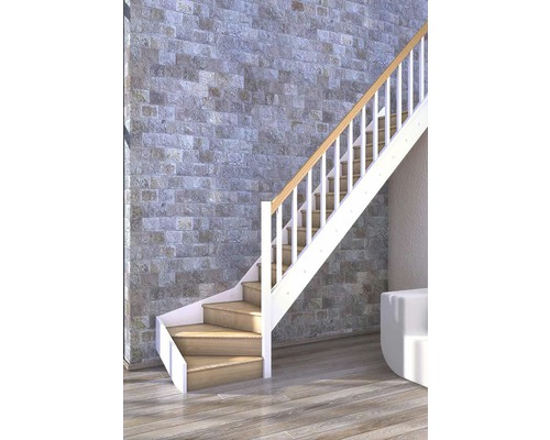 Scară cu trepte din lemn și balustradă albă în fața unui perete de piatră