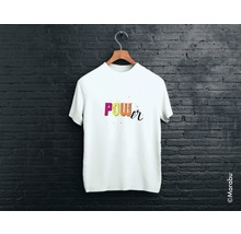 Tricou alb cu inscripția Power pe un umeraș în fața unui zid de cărămidă