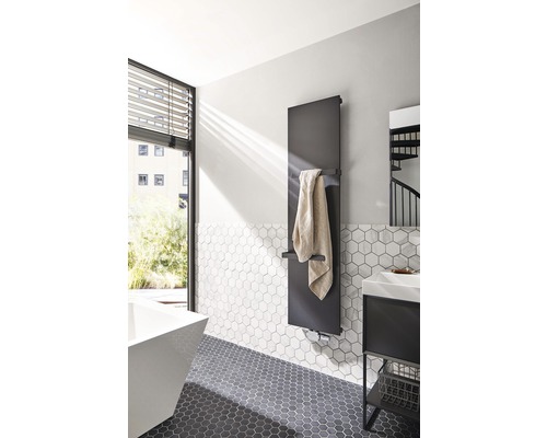 Baie modernă cu radiator pentru prosoape, chiuvetă și plăci hexagonale.