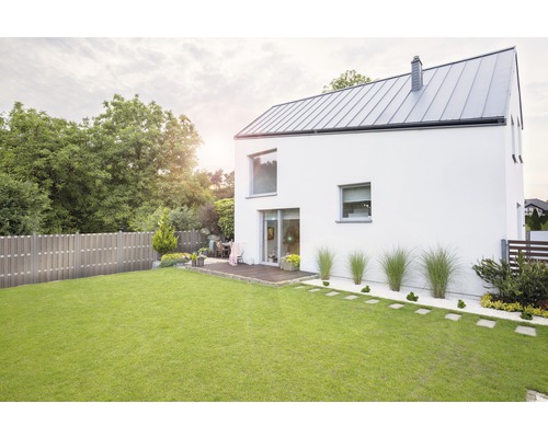 Vedere a unei case moderne cu grădină, gazon și gard din lemn