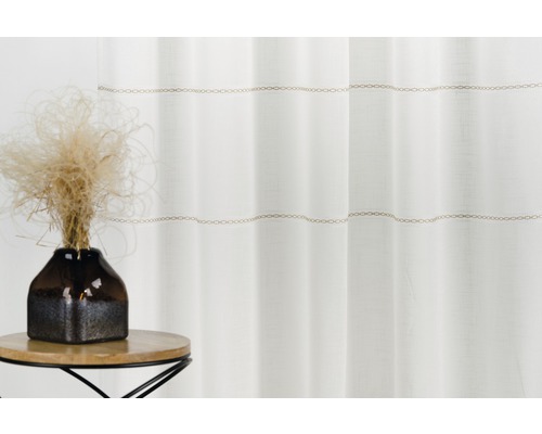 Perdea albă cu model de lanț și decorațiuni pe o masă