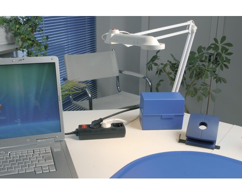 Spațiu de lucru cu laptop, prelungitor, lampă de birou și rechizite de birou