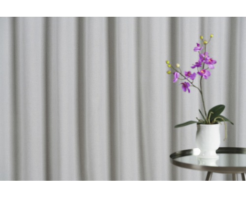 Orhidee decorativă violetă într-un ghiveci alb pe o măsuță