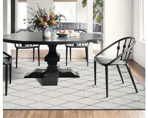 O sală de mese cu o masă rotundă, scaune și un covor cu model